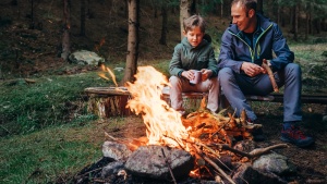 Père avec son fils assis ensemble devant un feu