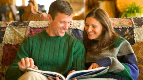 Un homme et une femme regardent un livre ensemble