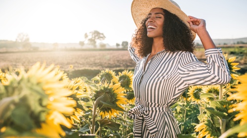 Une femme heureuse dans un champ de tournesols.