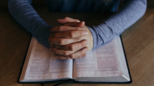 Un homme priant devant une Bible