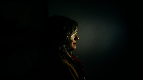 A woman standing in the dark.