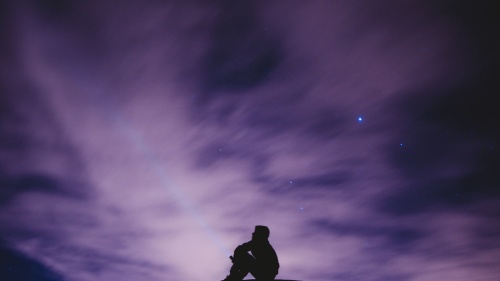 A man sitting looking at the stars.