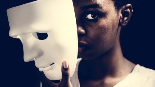 Une femme enlève un masque blanc de son visage