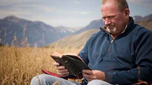 Un homme qui lit une Bible.