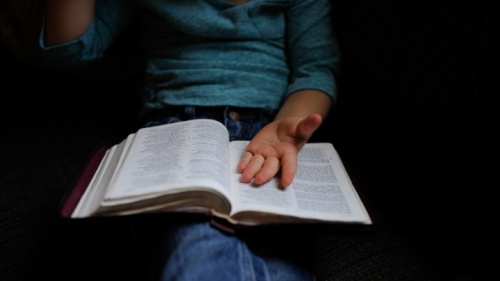 Une femme lit sa Bible et prie