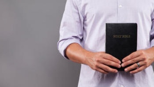 Un homme tenant une bible.