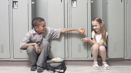 Un enfant partage son déjeuner avec sa camarade de classe