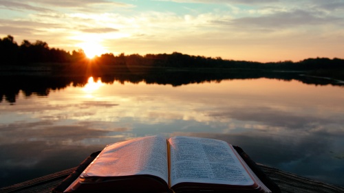 Une Bible sur une jetée au lever du soleil