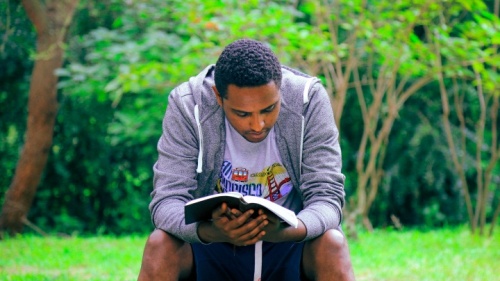 Un jeune homme lit la Bible
