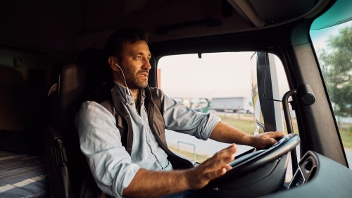 Chauffeur de camion utilisant des écouteurs lors d'un appel téléphonique