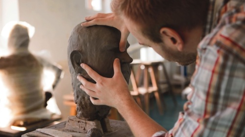 Une sculpture qui forme une tête humaine en argile.