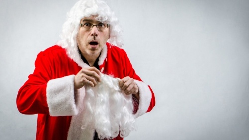 Un homme en train de se déguiser en Père Noël