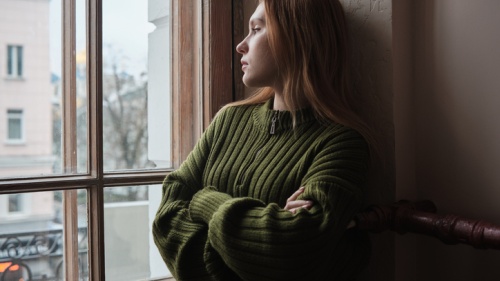 Une femme solitaire regardant par la fenêtre.