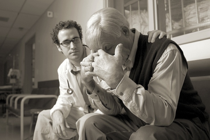 Un docteur donne du réconfort à un monsieur âgé