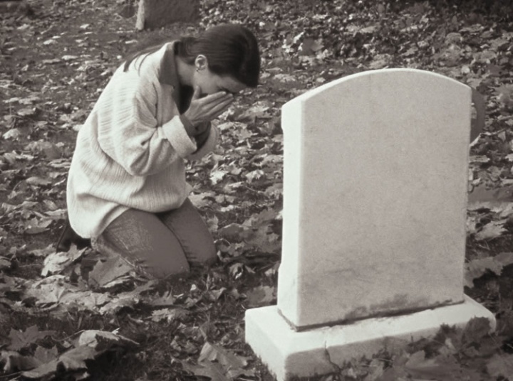 Une femme qui pleure près d'un tombeau