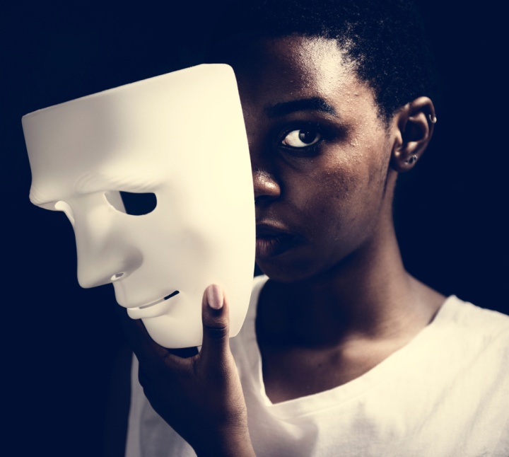 Une femme enlève un masque blanc de son visage