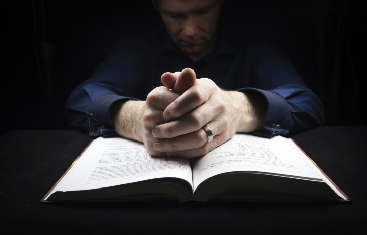 Un homme qui prie avec sa Bible