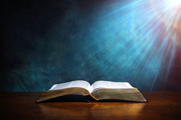 Une Bible ouverte avec une lumière qui l'éclaire d'en haut.