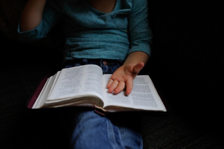 Une femme lit sa Bible et prie