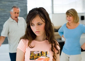 Adolescente en premier plan avec parents contrariés en arrière-plan