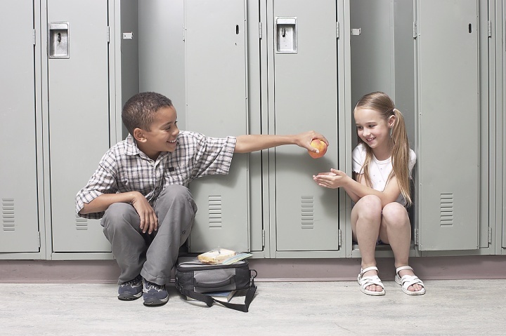 Un enfant partage son déjeuner avec sa camarade de classe