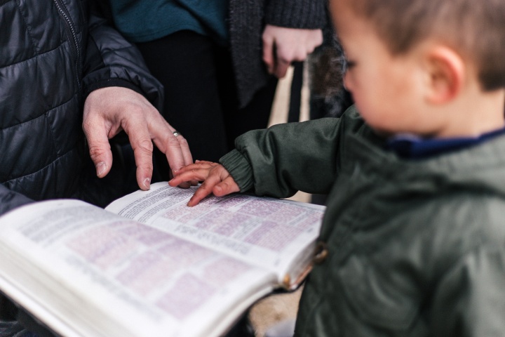 Un petit enfant regarde une Bible