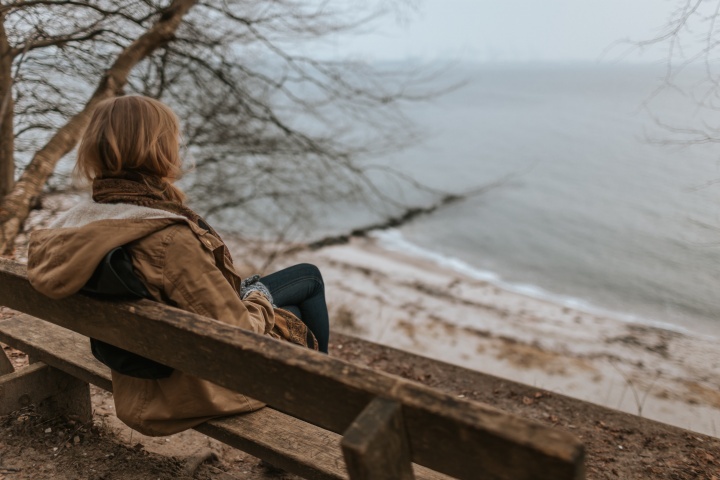 Une femme assise près d'un lac