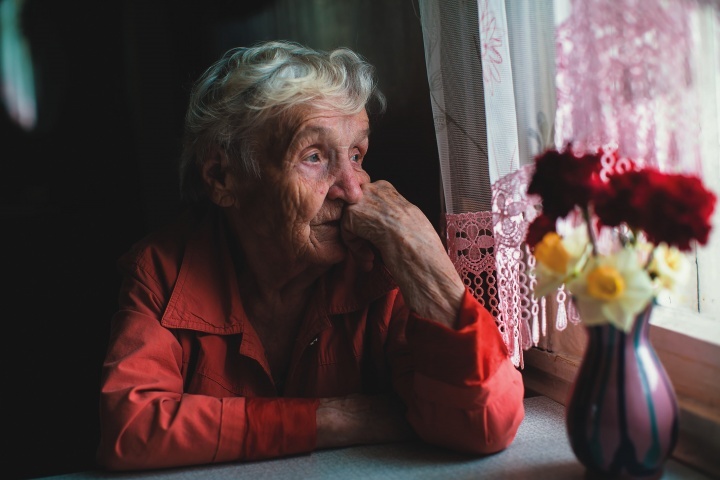 Une vieille dame regarde par la fenêtre