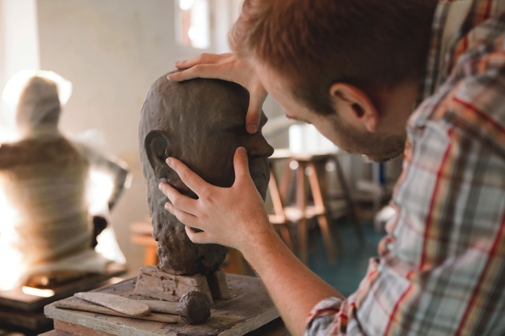 Une sculpture qui forme une tête humaine en argile.