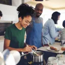 Famille multiraciale heureuse avec trois enfants cuisinant ensemble à la maison