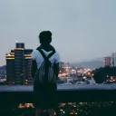 Une jeune femme regarde une ville depuis un belvédère