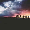 Les silhouettes des personnes devant un coucher du soleil