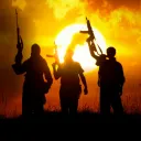 Trois hommes tenant des mitraillettes en l'air.