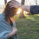 A woman with hands being laid on her in prayer after water baptism.