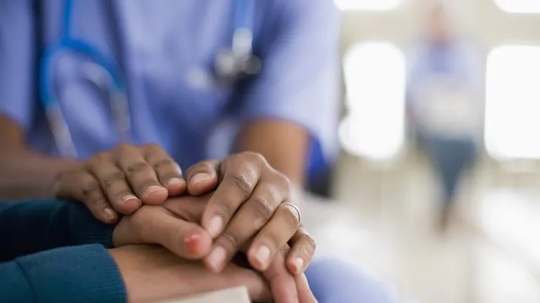 Des mains réconfortantes posées sur une autre paire de mains.