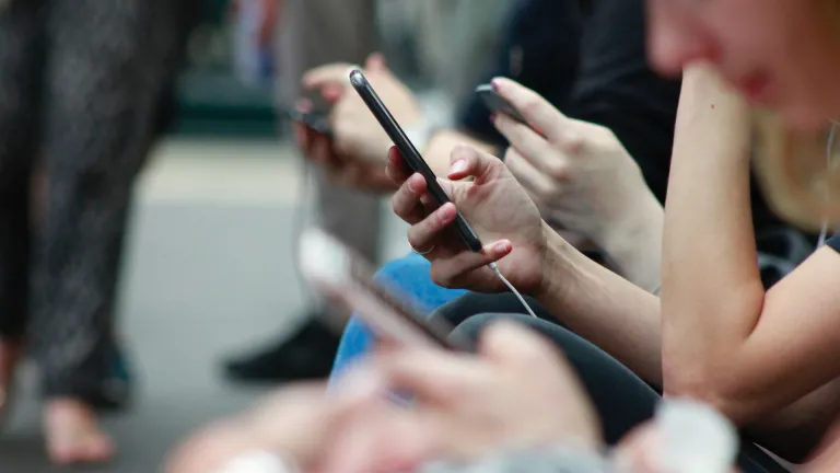 La technologie est une épée à double tranchant. Des personnes tenant des téléphones.