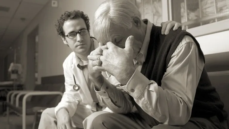 Un docteur donne du réconfort à un monsieur âgé