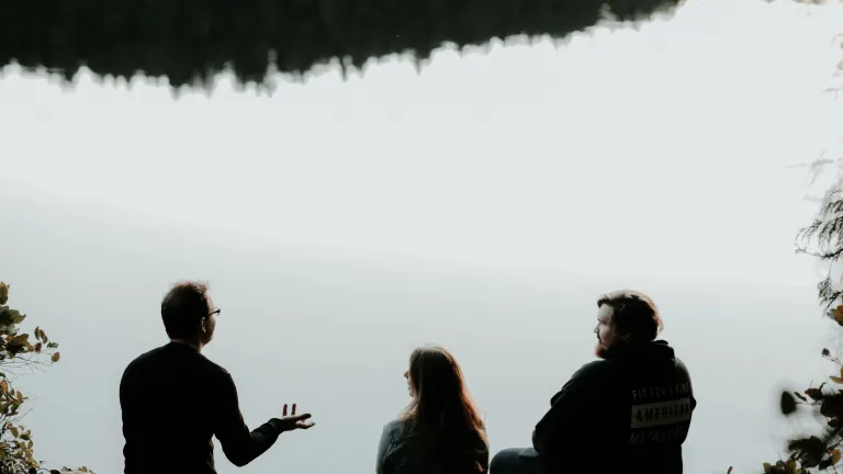Dieu s’attend à ce que la vérité imprègne chaque facette de notre vie. Trois personnes sont assis au bord d'un lac — une personne parle aux autres qui l'écoutent