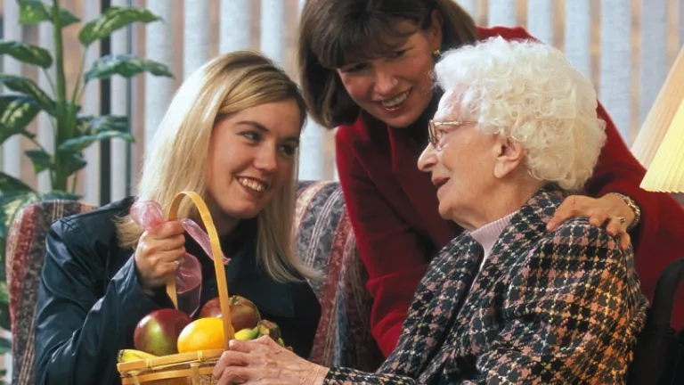 Une jeune femme et sa mère donne un cadeau à une vieille dame