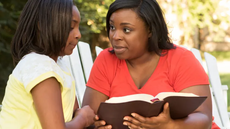 Une femme tenant une Bible avec sa fille.