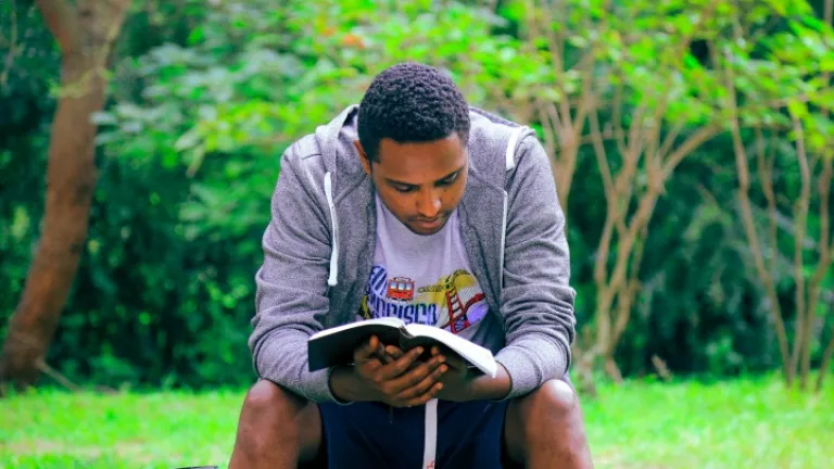 Un jeune homme lit la Bible