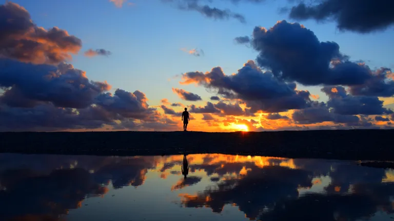 La silhouette d'une personne dans un coucher de soleil.