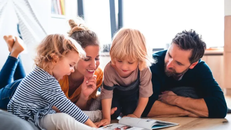 Une famille regarde un livre.