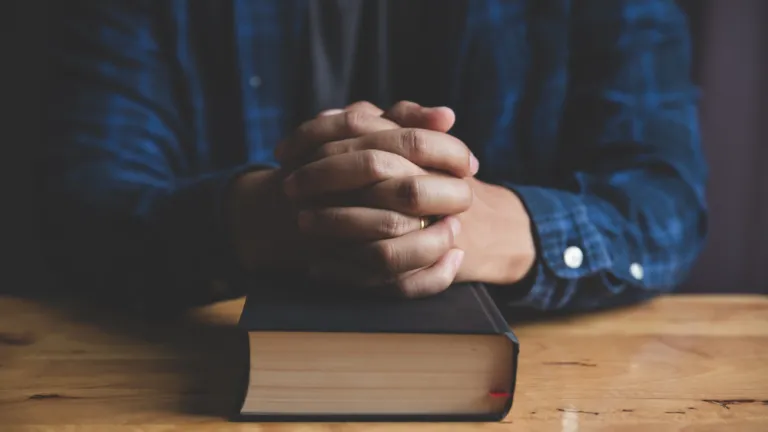 Un homme prie avec une Bible