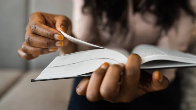 Une personne qui feuillette les pages d'une bible.
