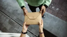 Une personne donne une enveloppe à une autre personne