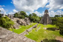 Vue des majestueuses ruines mayas avec herbe verte et arbres au parc national de Tikal au Guatemala, près de la frontière du Belize.