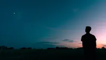 Une personne regardant un coucher de soleil.