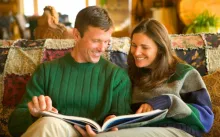 Un homme et une femme regardent un livre ensemble