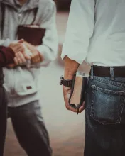 Deux hommes tiennent des Bibles à la main et parlent avec un troisième homme